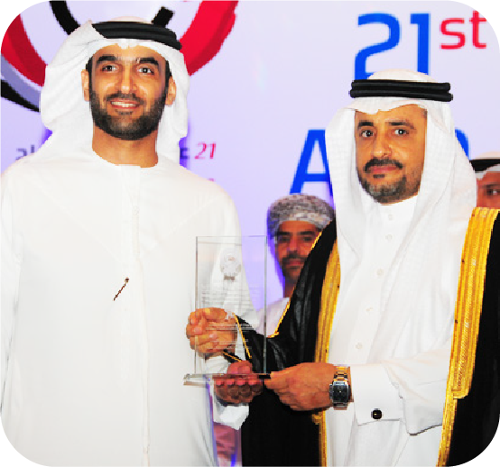 Honouree holding a glass trophy alongside a guest